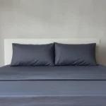 Midnight bamboo sheet set with matching pillowcases on a neatly made bed.