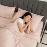 Woman sleeping peacefully under a soft pink bamboo weighted blanket and bamboo sheets in Singapore bedroom